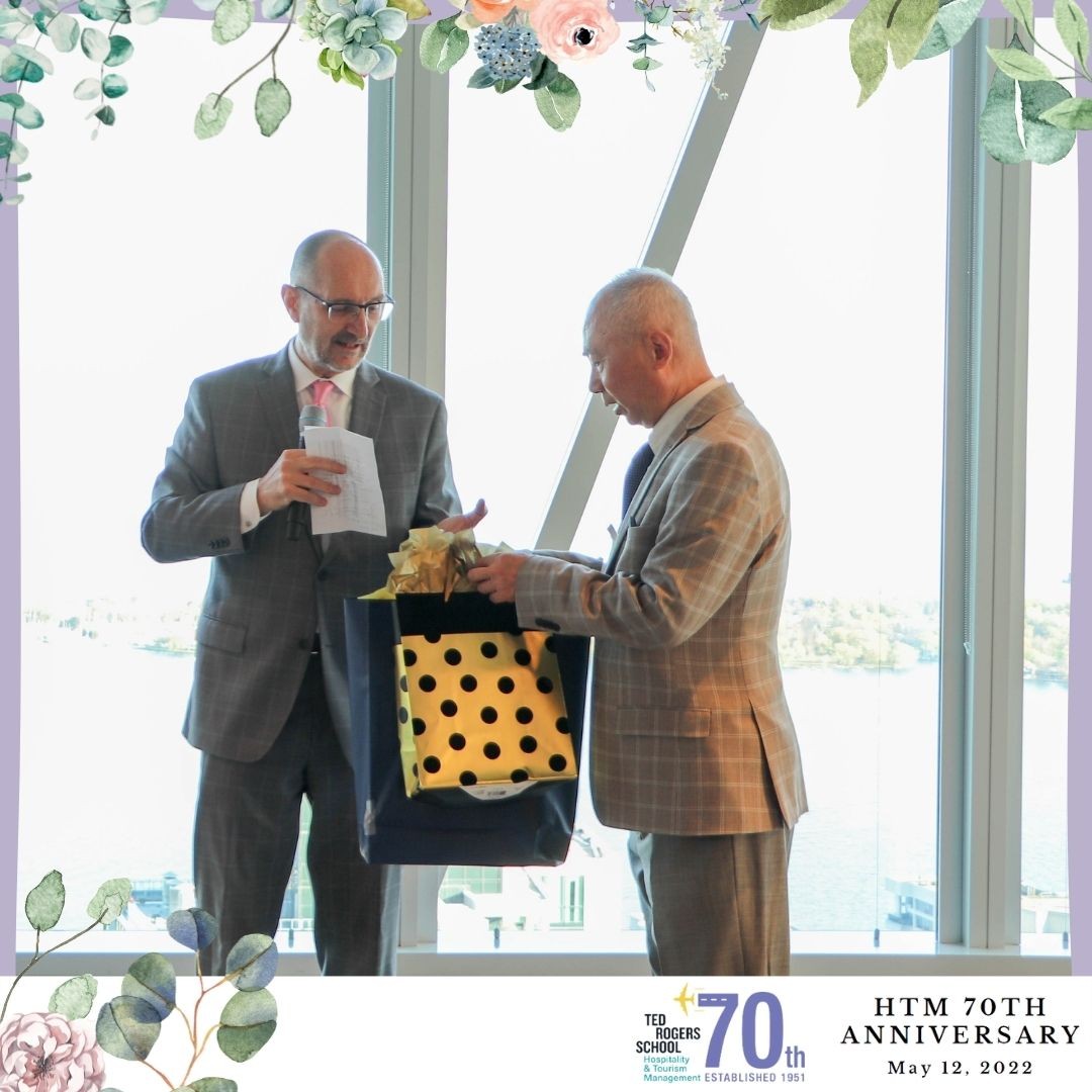 Dr. Frederic Dimanche with a man presenting an award at HTM's 70th anniversary event.
